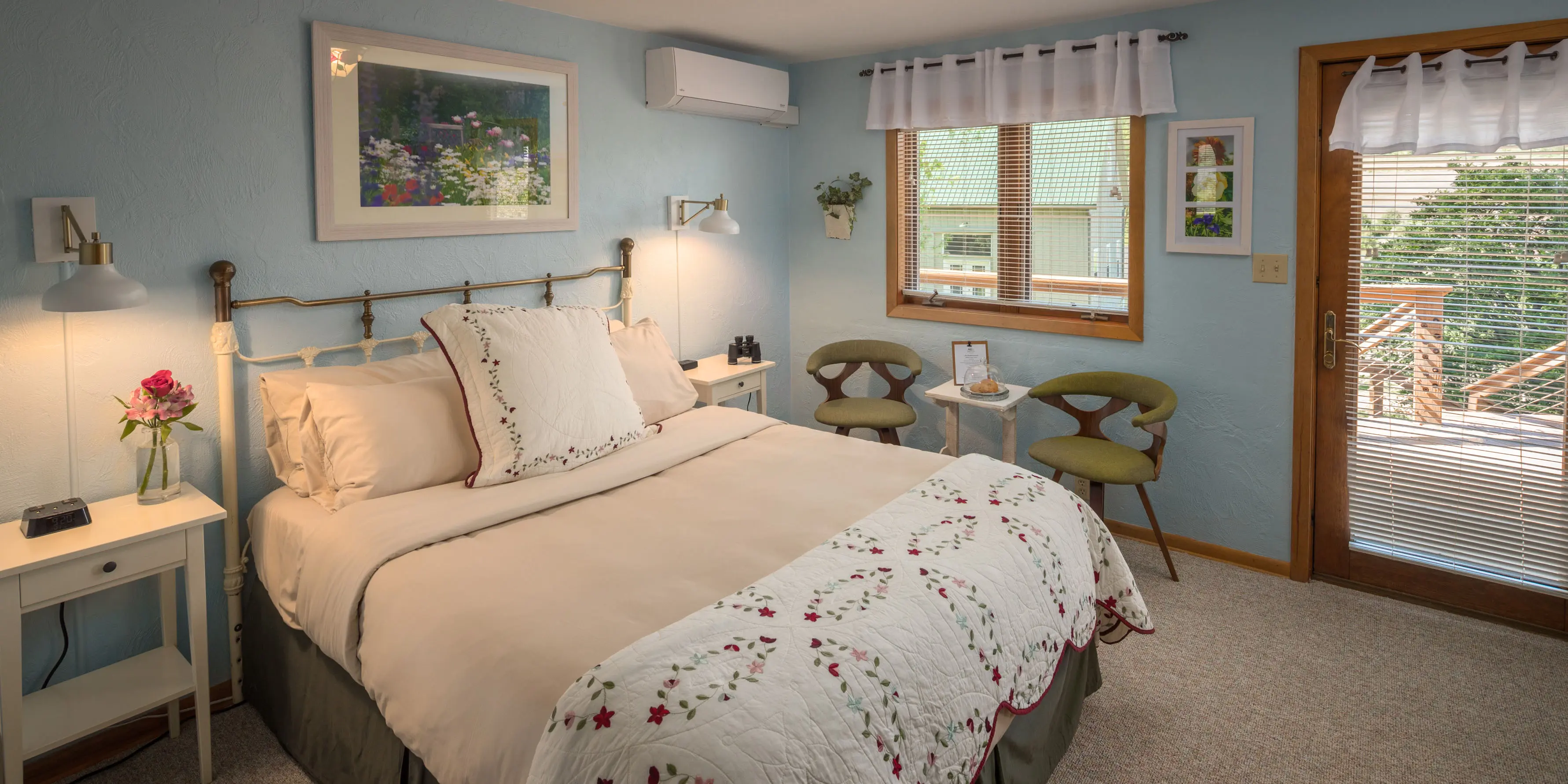 queen sized bed with 2 chairs in light blue room