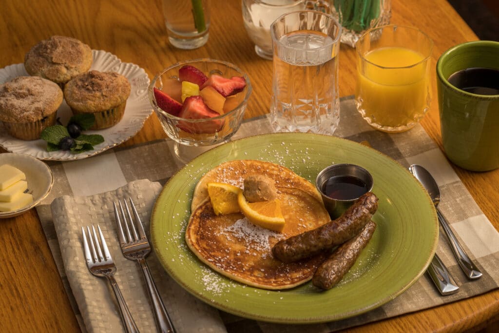 pancakes, sausage, fruit, muffins, juice and coffee