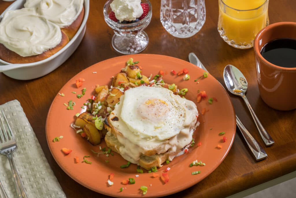 Croque Madame, potatoes, cinamon rolls, fruite, juice and coffee