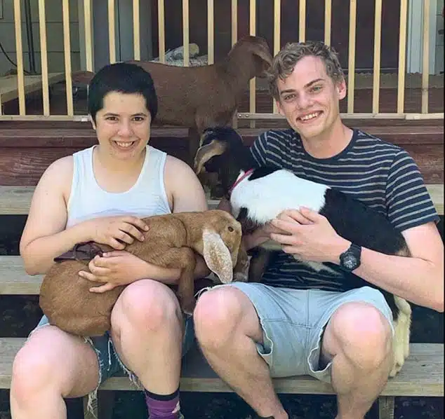 a young couple holding two goats