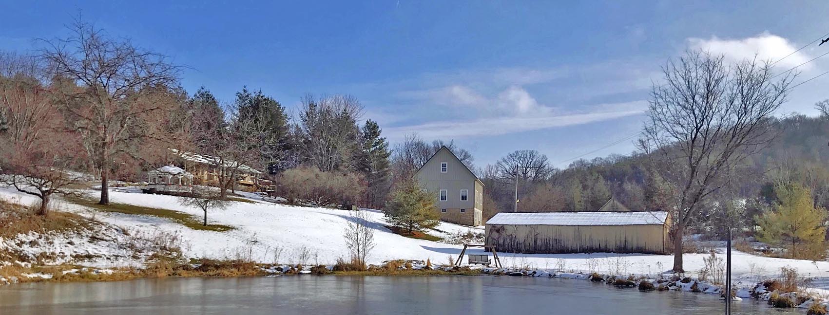 looking at barn and house from pond in winter