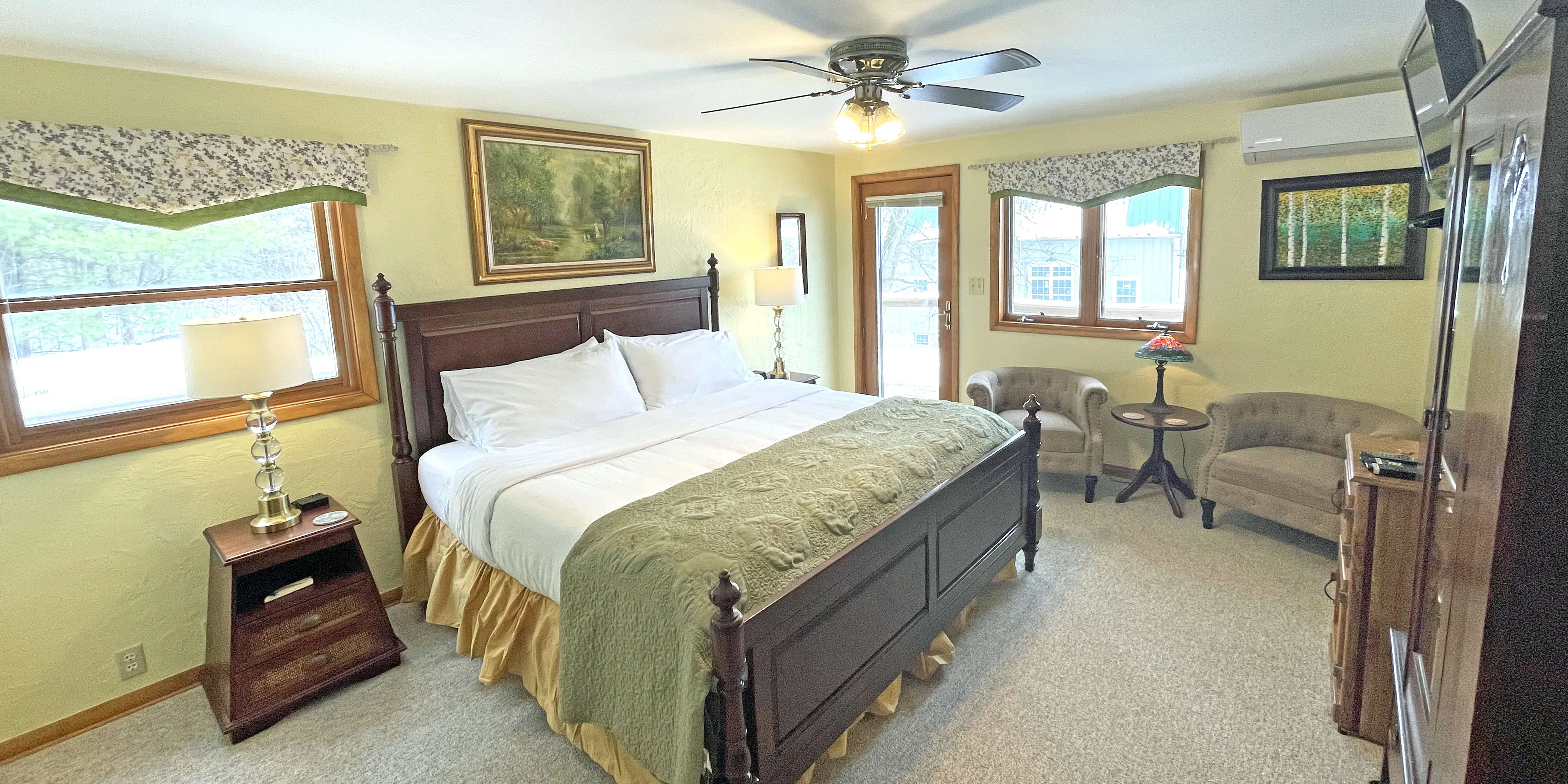 view from door with large bed, chairs, wardrobe. Yellow walls and meadow accents