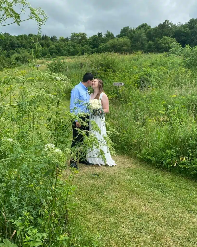 newly married couple posing in field