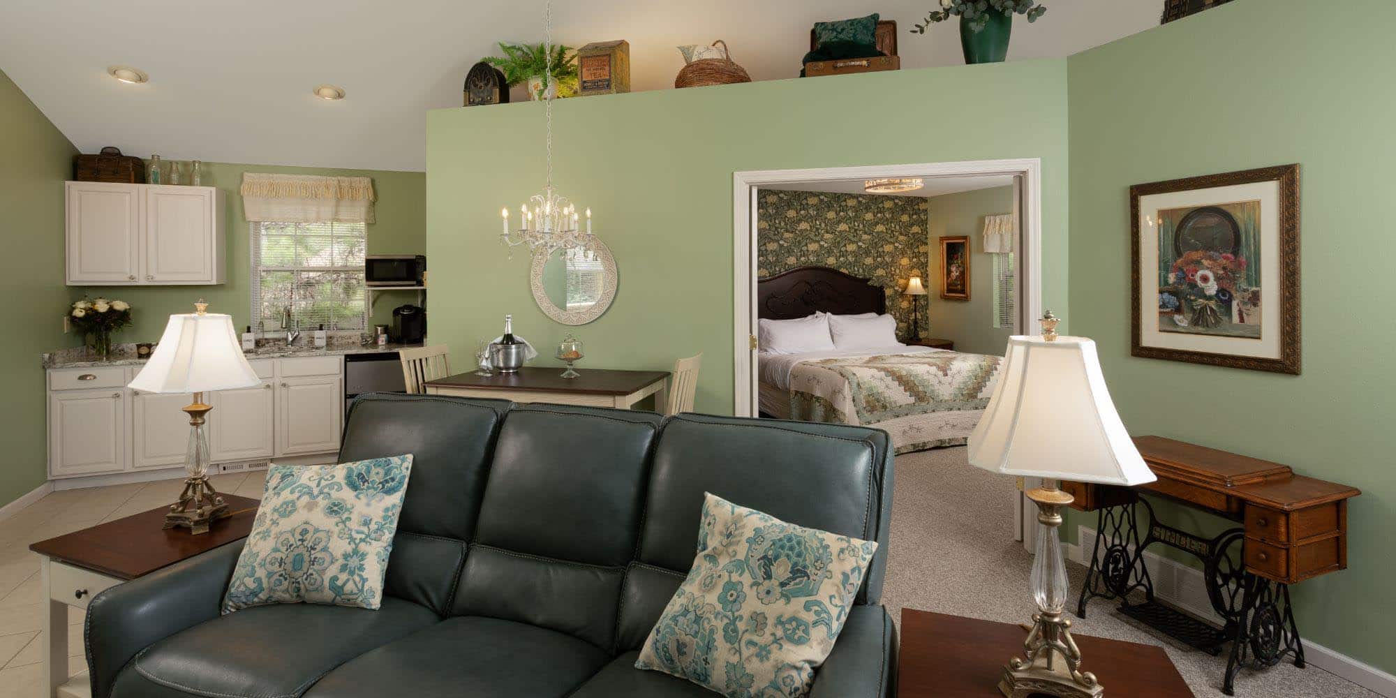 overview picture with large couch, kitchen and bedroom in backround