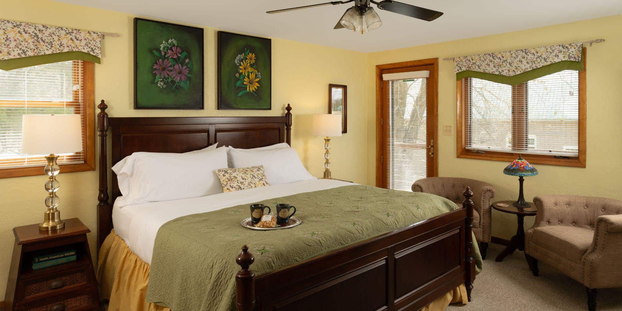 large bed with 2 chairs in yellow room